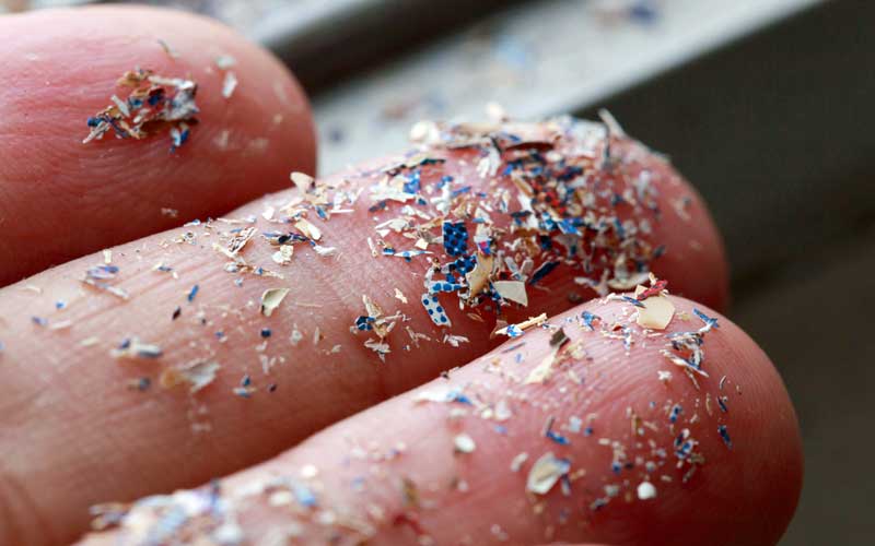 Microplastics on fingertips.